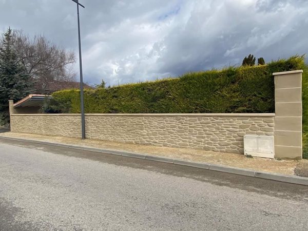 Long mur de cloture en imitation molasse par La PIerre d'Uzel à Alixan (26) pour des finitions parfaites pour votre habitation.