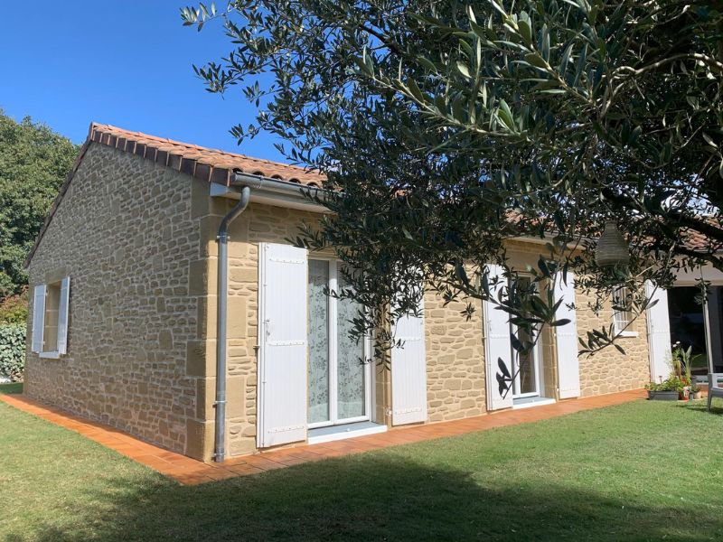 Résultat d'une façade imitiation molasse avec deux portes-fenetres aux volets blancs et un olivier.